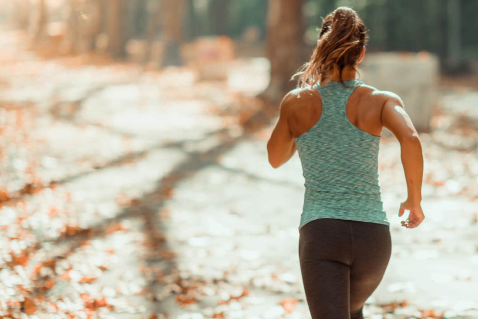 Woman running in the autumn sunshine - 20 tips for running motivation