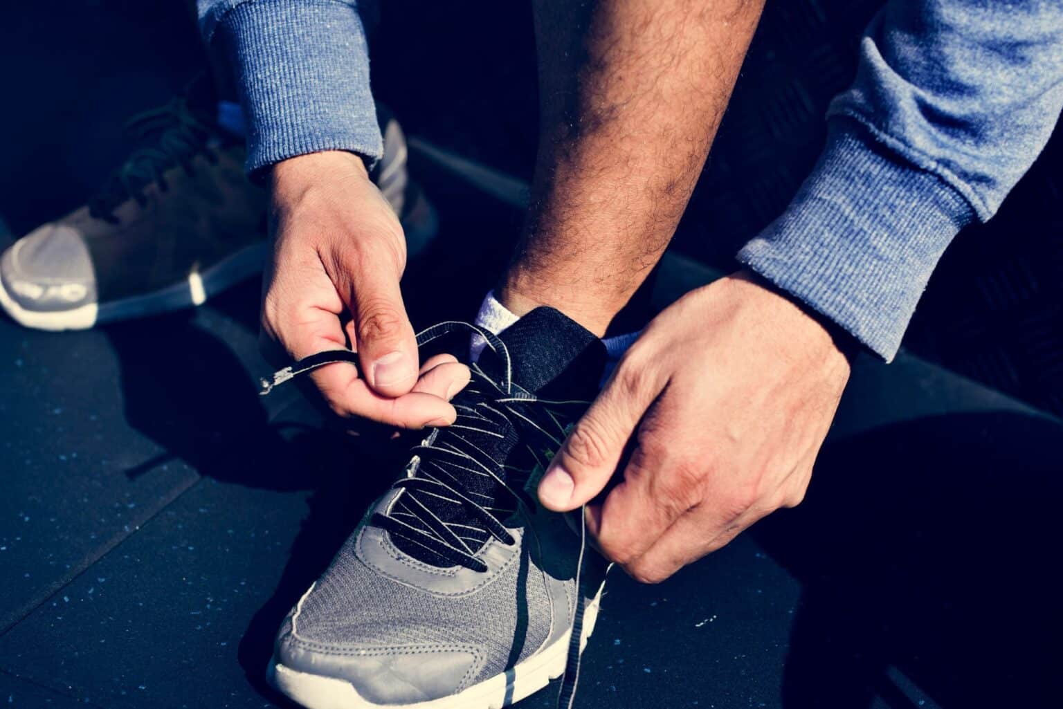 How-long-should-a-half-marathon-training-plan man lacing shoes