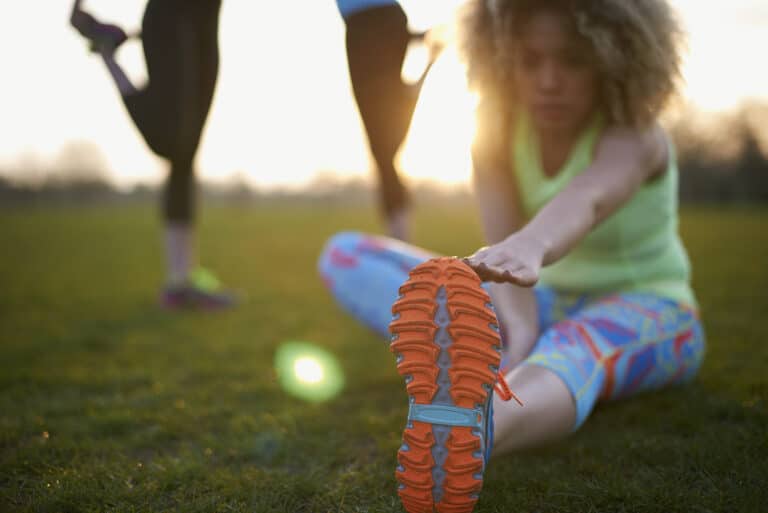 Runner stretching with injury, in London Marathon training